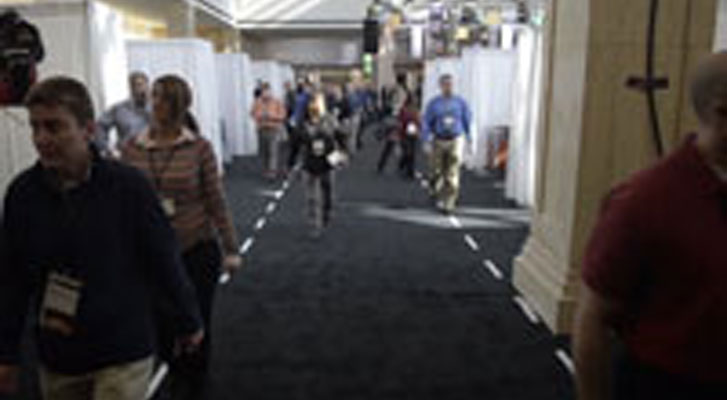 Image: Tradeshow attendees walk through exibits. Trade Show planning nad logistics managed by Benchmarc360.
